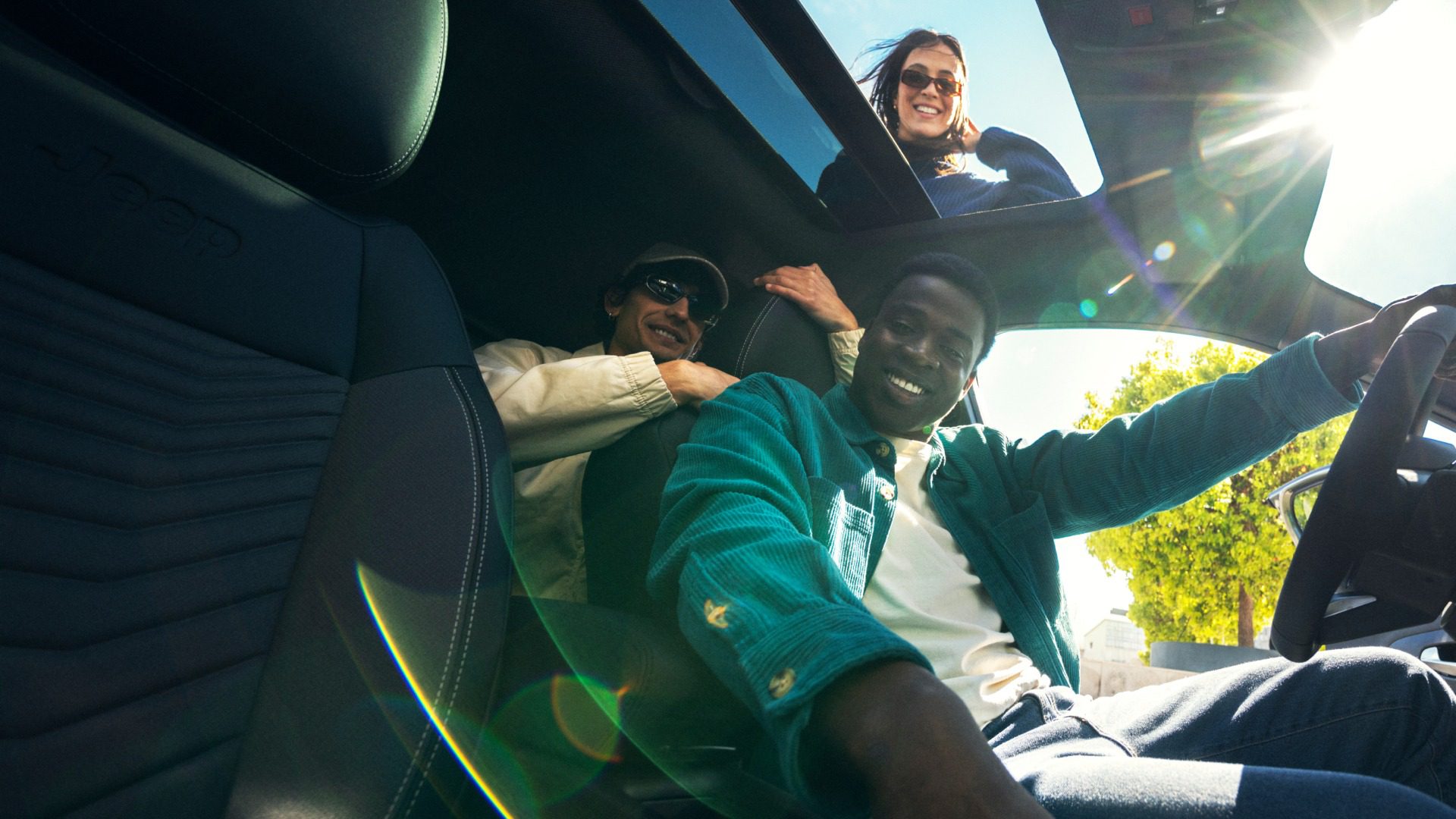 Drie personen in het interieur van de Jeep Avenger met geopend panoramadak