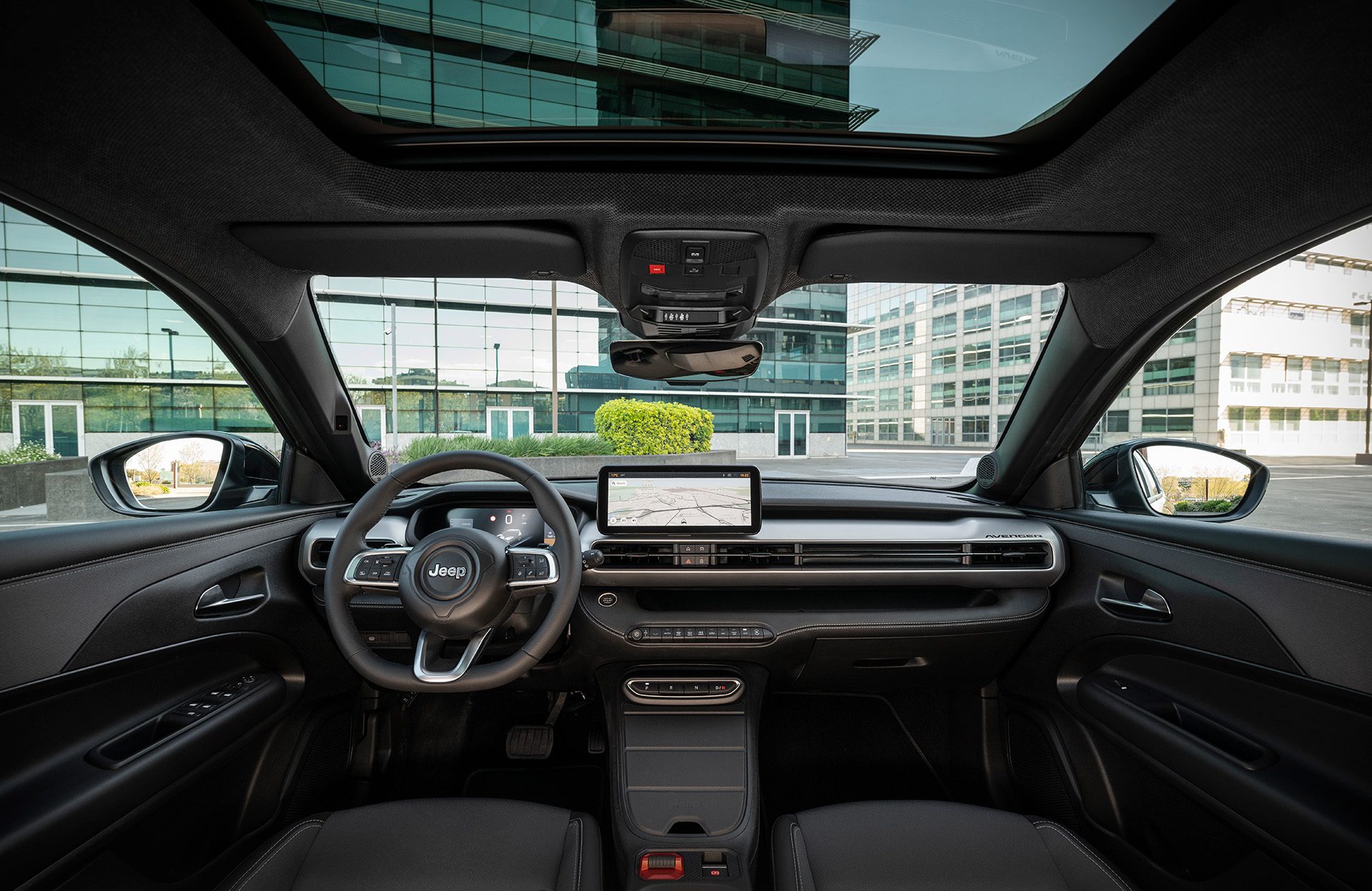 Interieur van de Jeep Avenger 4xe met digitaal instrumentenpaneel, centraal touchscreen en panoramadak